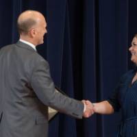 Woman smiling shaking hands with Dean Potteiger as she receives her award